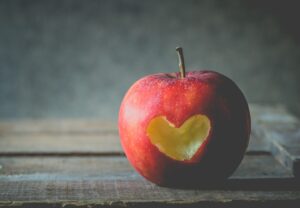 A képen egy alma látható, amiből egy szív formájú falat hiányzik